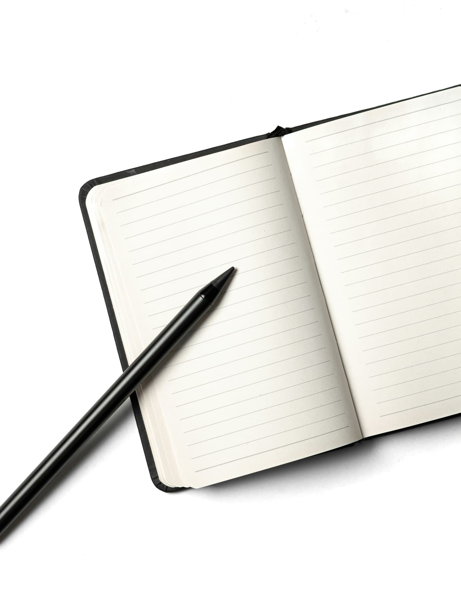 An open notebook and pen on a white desk